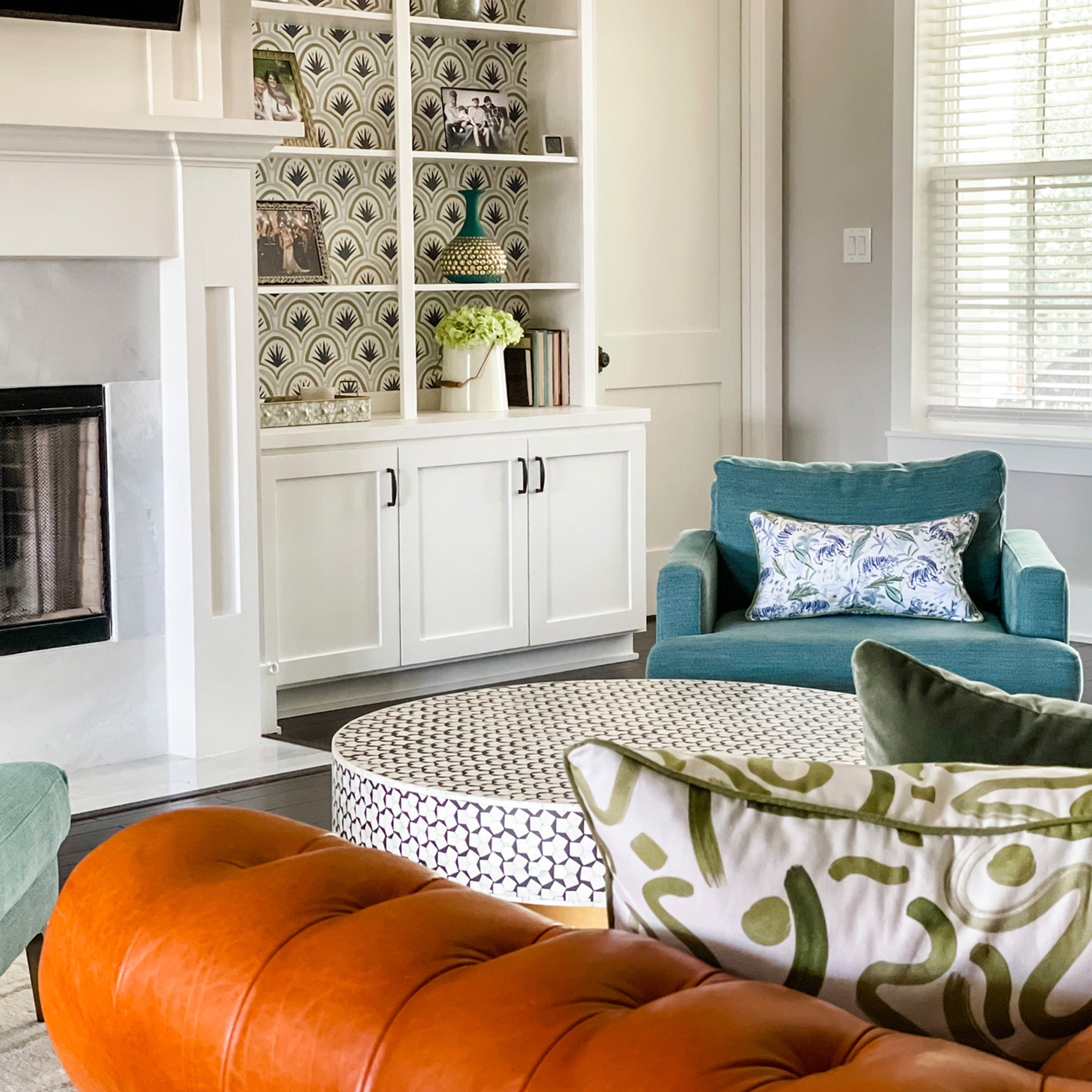 Frida Green pillow with botanical print on teal chair in bright living room, made-to-order in the USA with quick turnaround