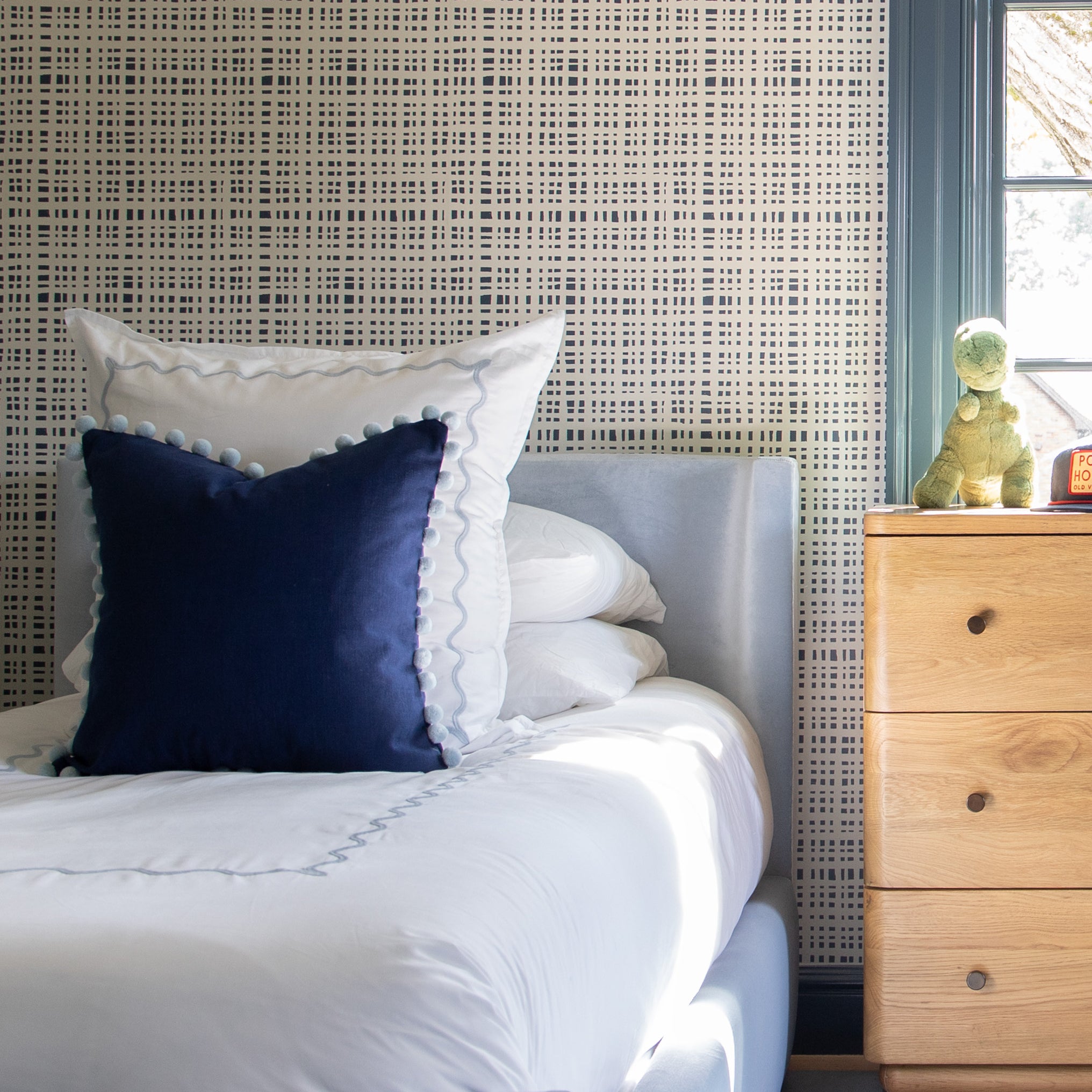Sky made-to-order bedding set with navy accent pillow and textured white linens, manufactured in the USA with short lead times