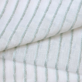 close up of sheer white fabric with mint green embroidered stripes 