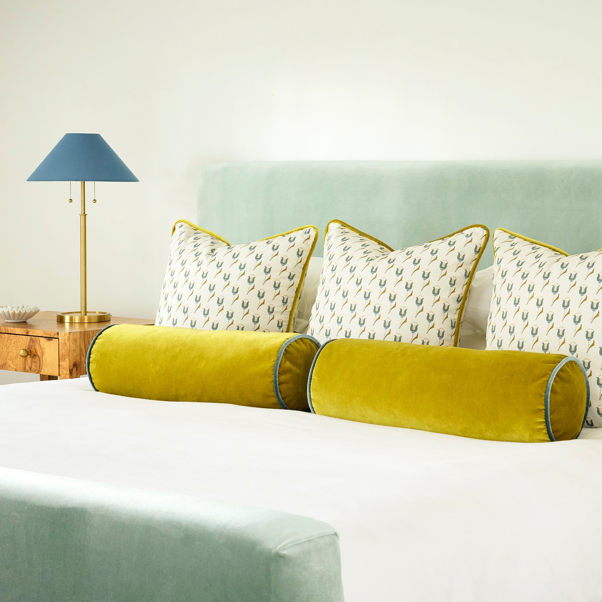 Sea Salt made-to-order bed with green velvet bolsters and patterned pillows, crafted in the USA with quick turnaround