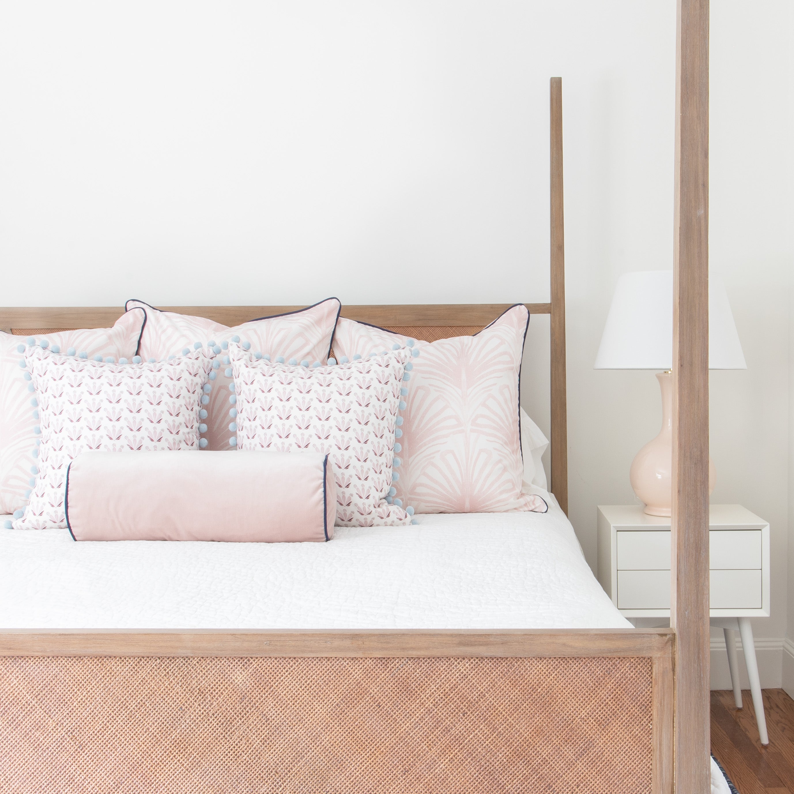 Suzy Rose made-to-order pink patterned pillows and bolster with blue trim on bed, crafted in the USA with short lead times